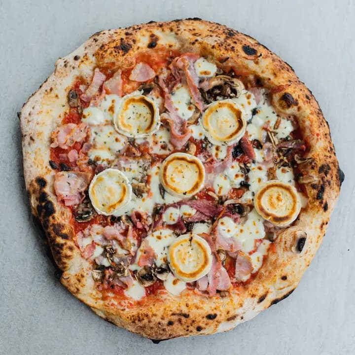 Neapolitan pizza (Emilio) with mushrooms, pancetta, goat cheese and garlic